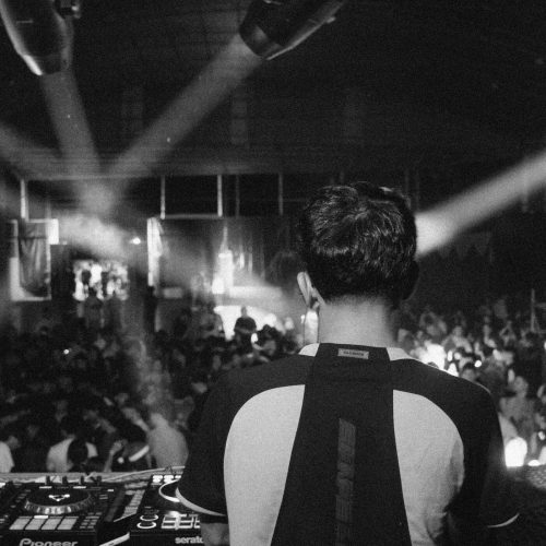 DJ performing for a crowd under stage lights